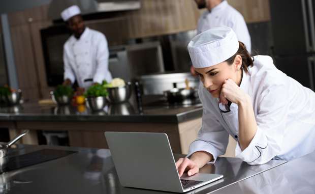 Chef using laptop at restaurant kitchen