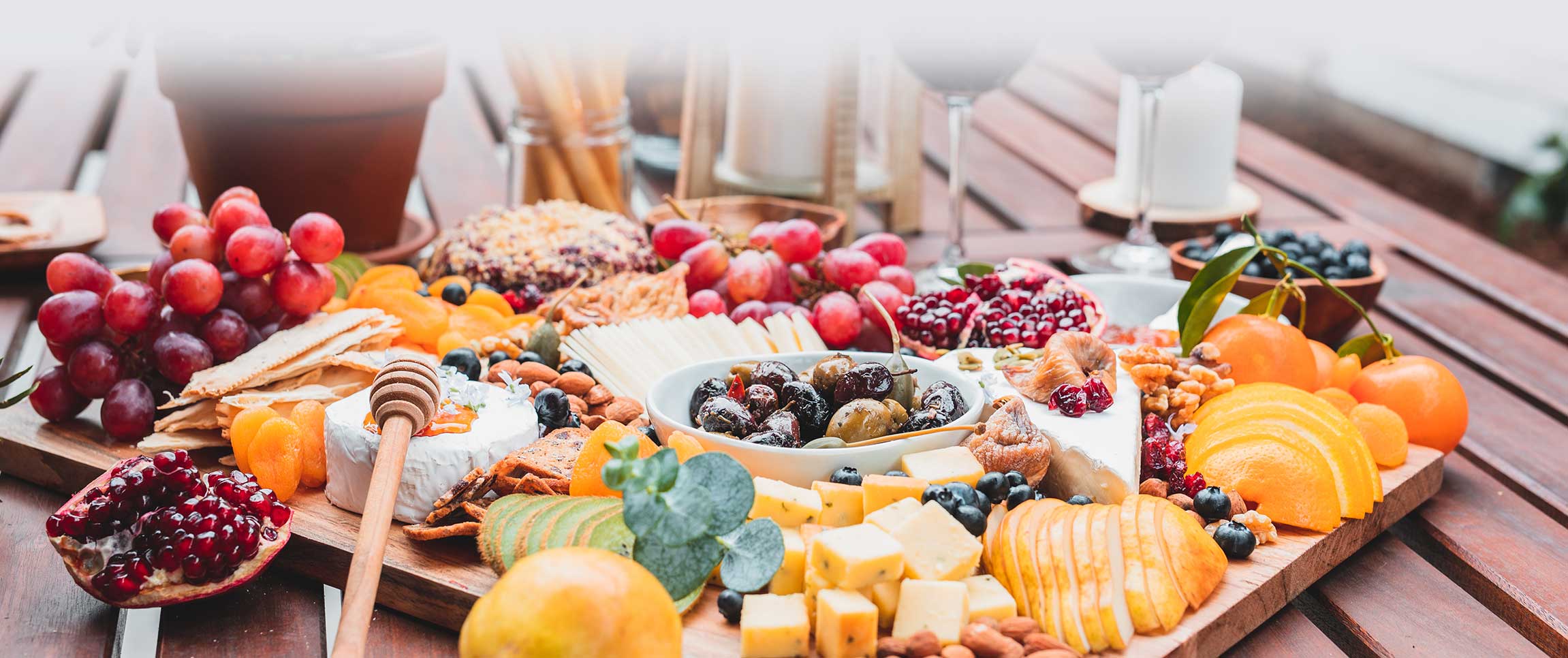 Artisan charcuterie boards kiwi grapes jam pomegranate olives cheese apricot kiwi orange almond food on the table