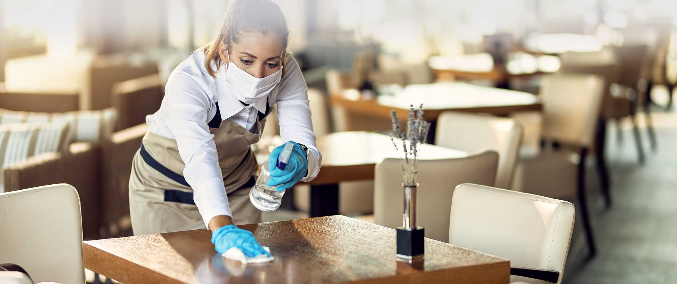 Restaurant Worker Sanitizing Table