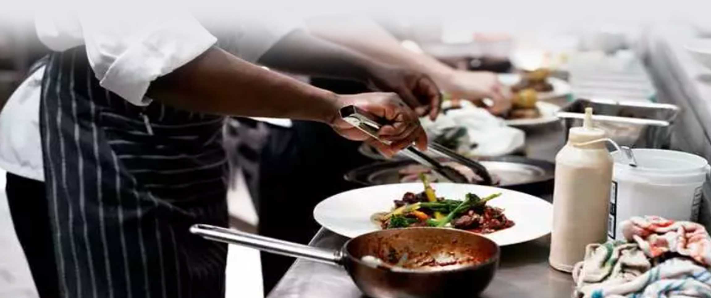 Chef Plating food with a pair of tongs