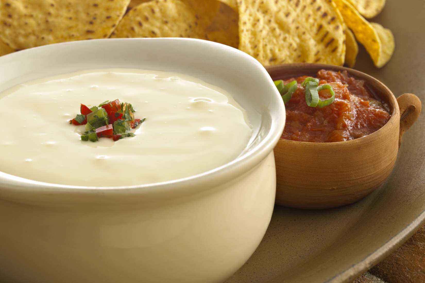 Bowl of queso with chips and salsa
