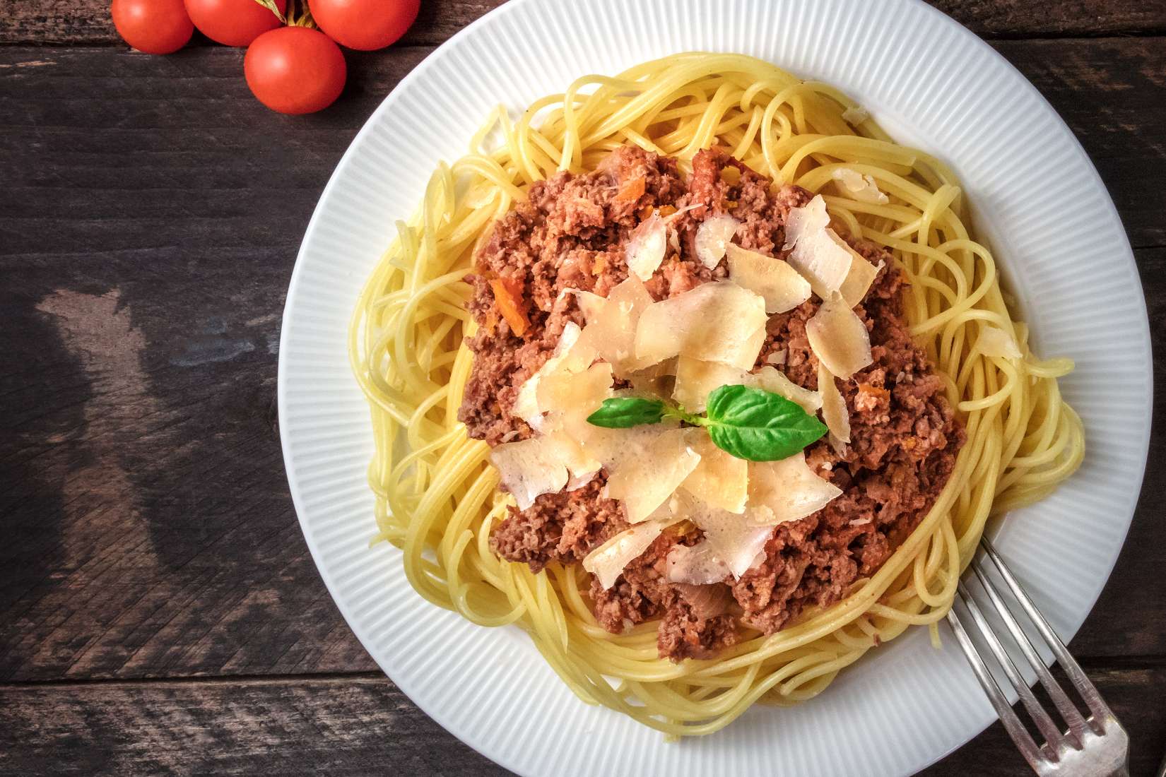 Plate of spaghetti topped with shaved parmesan.