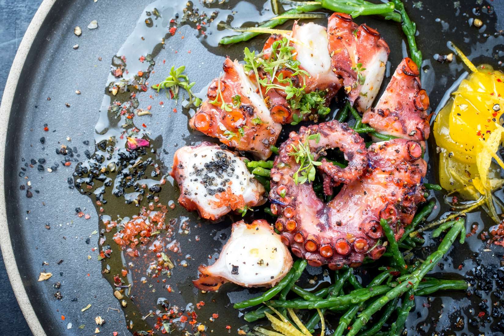 Octopus on slate with herbs and spices.