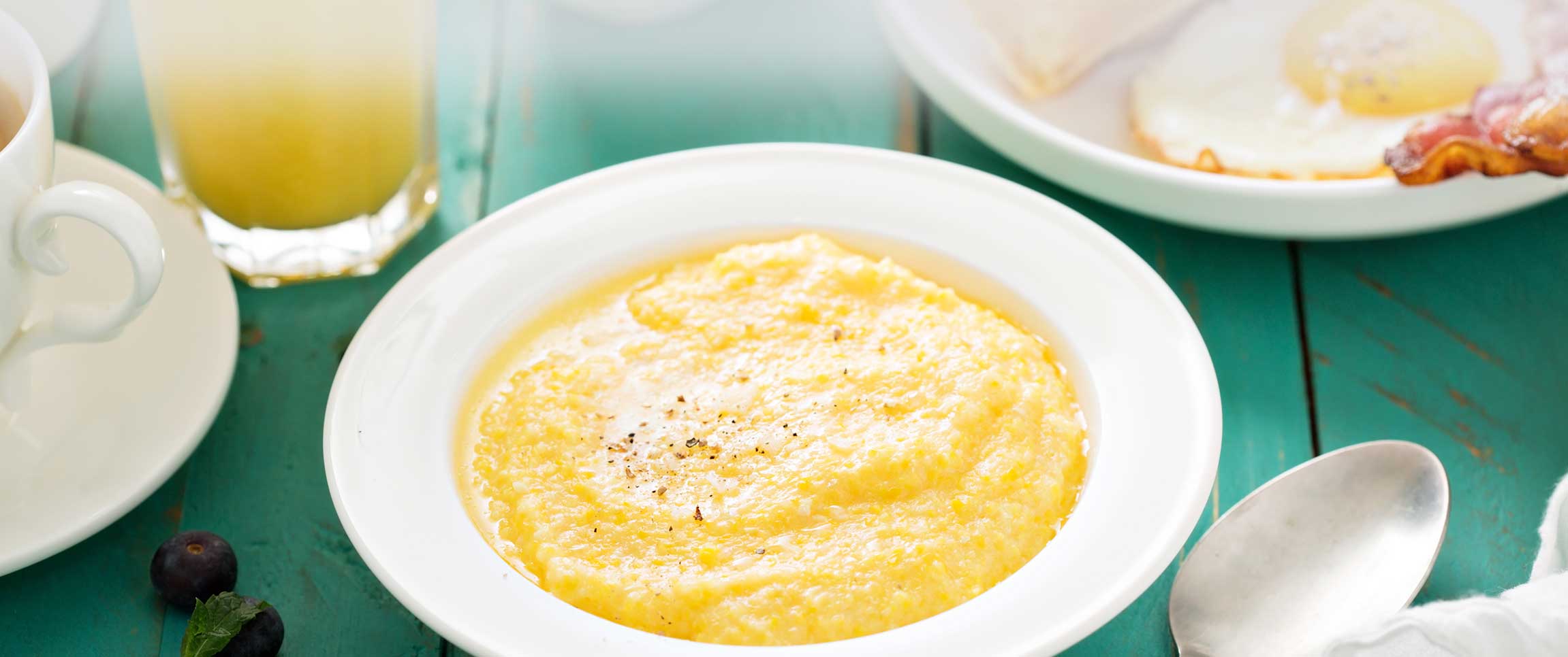 Cheesy grits with butter in a white bowl for breakfast