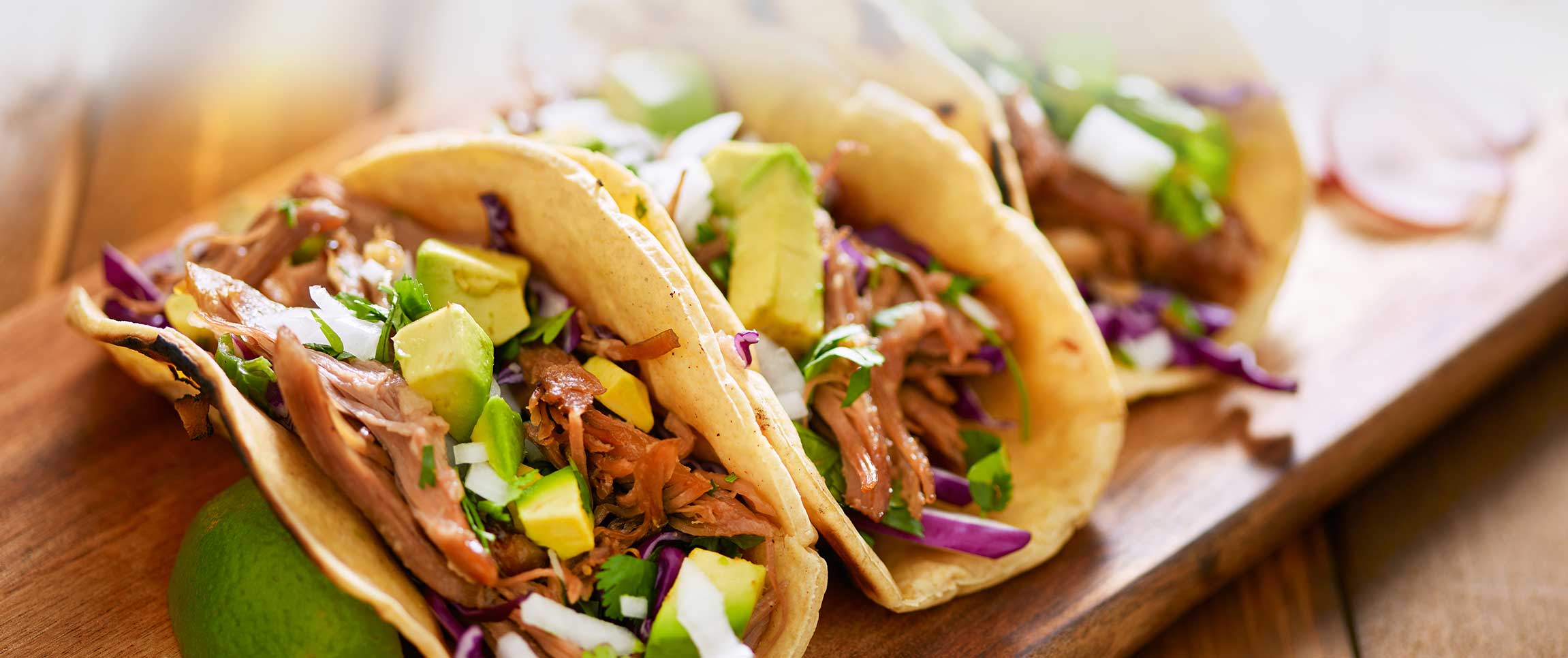 Pork belly diced atop a corn tortilla with shredded cabbage and an ancho chili and pineapple coulis