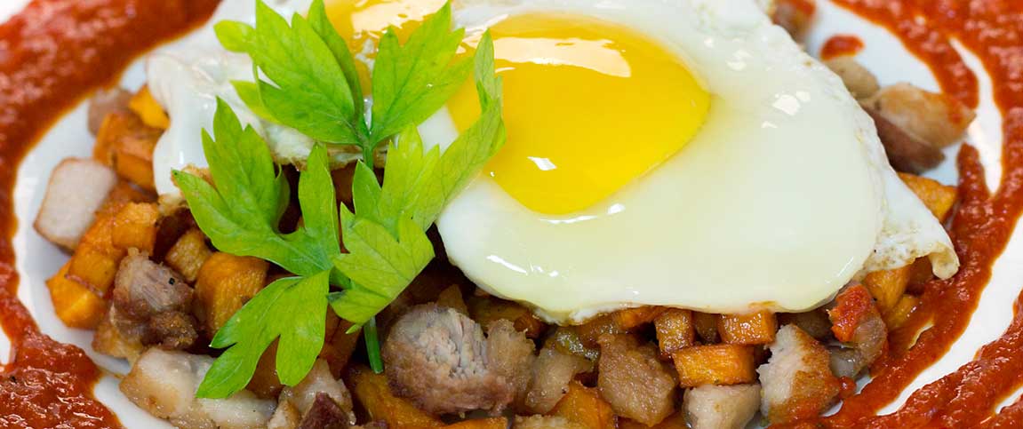 Pork Belly Sweet Potato Hash with Harissa Sauce and a Sunny Side Up Egg