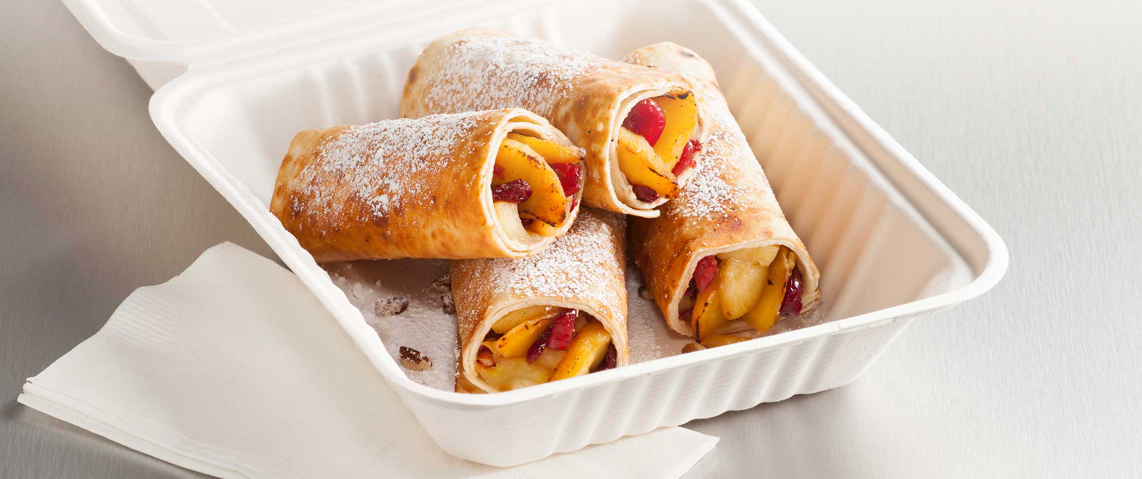 Roasted Fuji Apple Taquitos in a takeout box