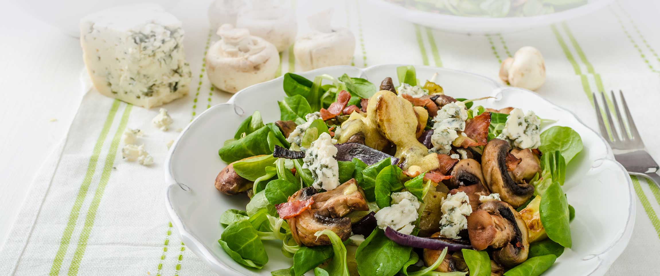 Peak baby spinach salad with crisp bacon, goat cheese and blistered cherry tomatoes then tossed with Piancone Roasted Red Pepper Vinaigrette