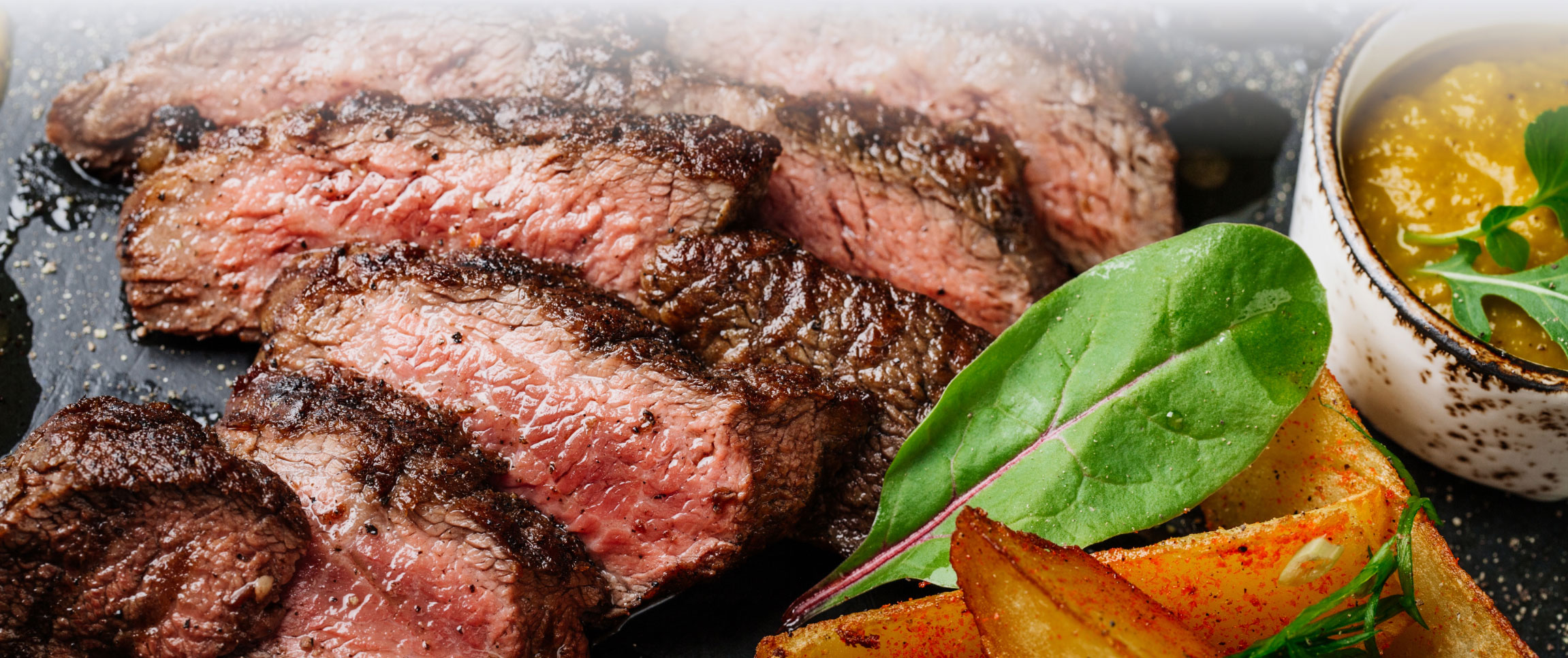 Sliced and Seasoned Cooked Beef Served with Sauce and French Fries