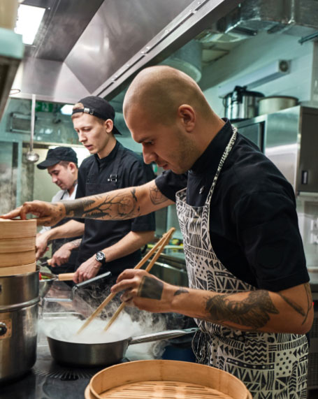 Chef Cooking in a Kitchen with Other Chefs